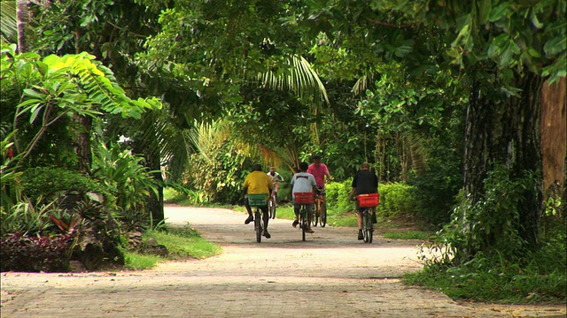 塞舌尔，拉迪格，人们在乡村公路上骑车视频下载