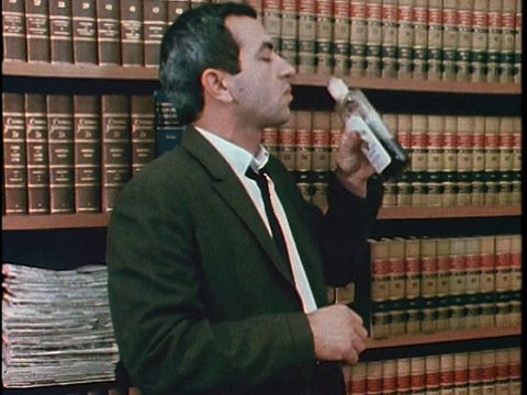 1967年，美国加州洛杉矶，一名男子在办公室喝酒视频素材
