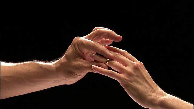 靠近男人的手把结婚戒指戴在女人的无名指上/女人的手展示戒指视频素材