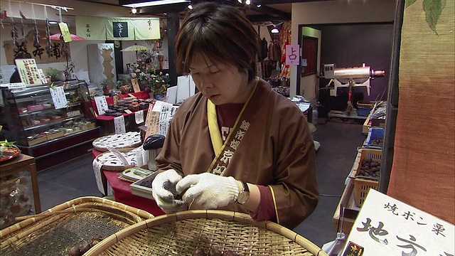 女士剥栗子，Nishiki市场，京都，日本视频素材