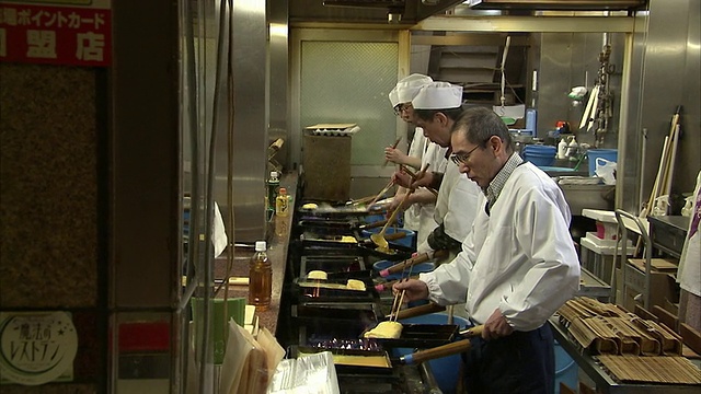 日本京都，四名男子在Nishiki市场餐厅厨房准备煎蛋卷视频下载