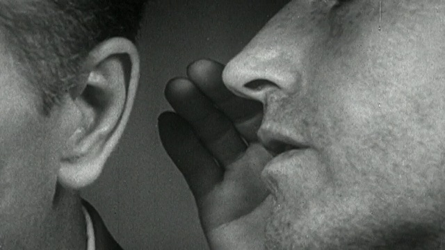 1952年，一名黑人和白人男子对着另一名男子的耳朵低语视频素材