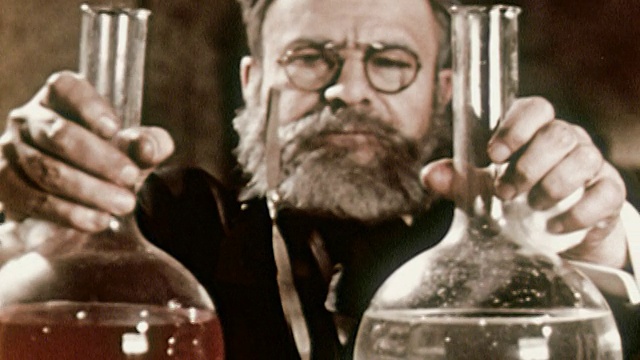 1953年再现中镜头科学家路易斯·巴斯德在烧瓶中混合透明和红色的化学物质视频素材