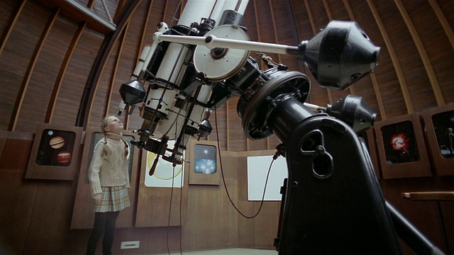 低角度广角镜头倾斜下屋顶，女孩进入天文台/女孩通过望远镜看视频下载