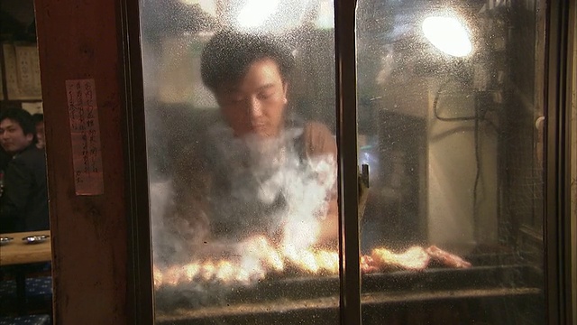 日本东京，透过水汽弥漫的窗户看到的曼女士正在烧肉烧鸡视频下载