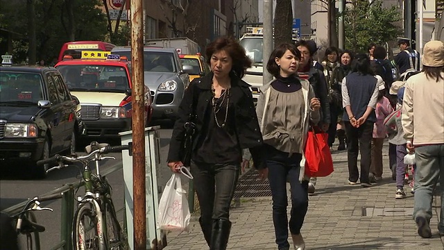 日本东京，一名拿着购物袋走在街上的女子视频下载