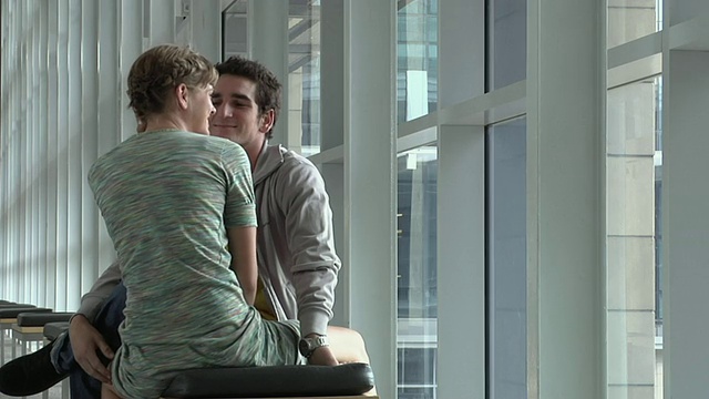 一对年轻的情侣在接吻，男人在看手表，开普敦，南非视频下载