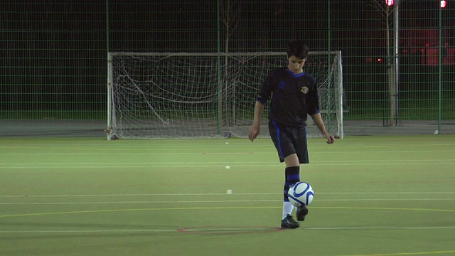英国伦敦，WS男孩(14-15)在足球场上做后防视频素材