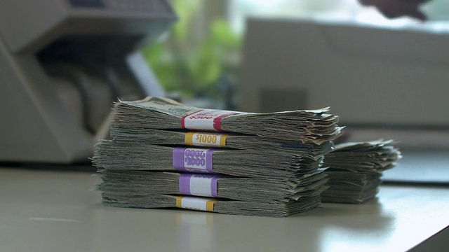 美国宾夕法尼亚州伯利恒，cuc收银员使用点钞机处理现金视频素材