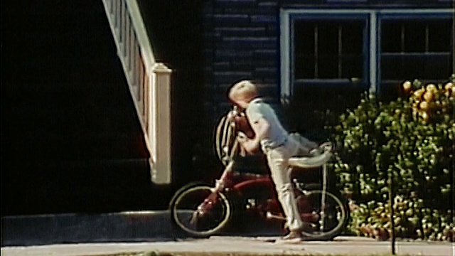 1969年，一个中枪男孩走在大楼前，骑上一辆带香蕉座的自行车，骑走了视频下载
