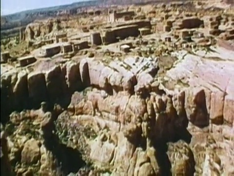 1975年，在mesa和绿树成荫的山谷的建筑物上空飞行/ mesa Verde，科罗拉多州视频下载