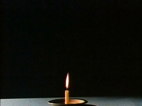 1975年延时中镜头蜡烛在黑色背景下燃烧到灯芯视频下载