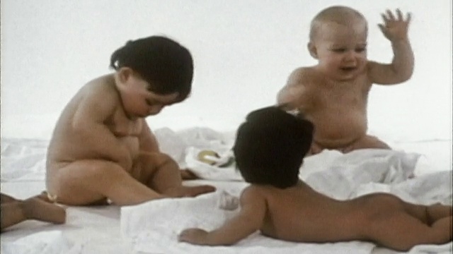 1985年，在白色背景下拍摄赤裸婴儿坐在白色毯子上玩耍视频下载