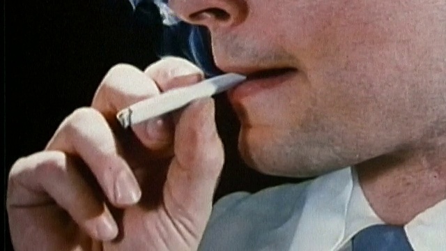 1987年近景男子的手划火柴/点烟，抽着烟，呼气视频下载