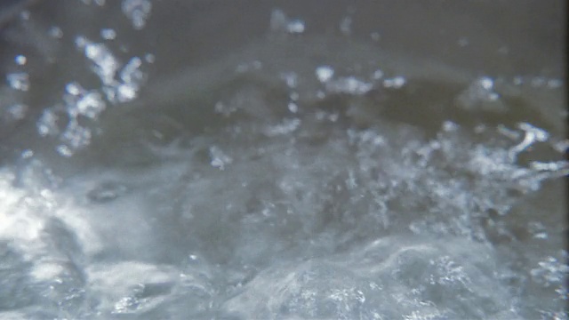 高角度极端近镜头缩小沸腾的水在锅里冒泡视频素材