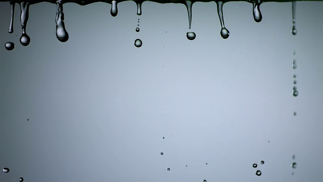 SLO MO CU对焦，在蓝色背景下拍摄水滴下落视频下载
