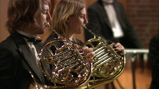 在英国伦敦管弦乐团演奏法国号的男士和女士视频下载