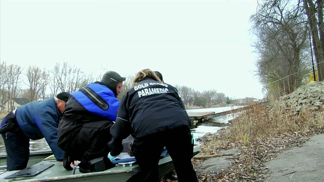 医学护理人员从船上抬起昏迷的女孩(14-15岁)，走向陆地，新伦敦，威斯康星州，美国视频素材