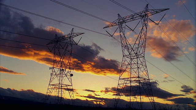 日落时分，乌云在高压电力塔上翻滚，美国加利福尼亚州Trona视频下载