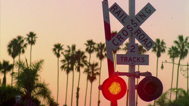 日落时分，美国加州蒙特西托，加州铁路十字路口的棕榈树标志视频下载