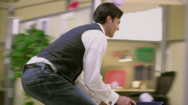 美国威斯康辛州阿普尔顿市，一名办公室职员穿着轮滑鞋，手里拿着回收箱，同事们向他扔纸片视频下载