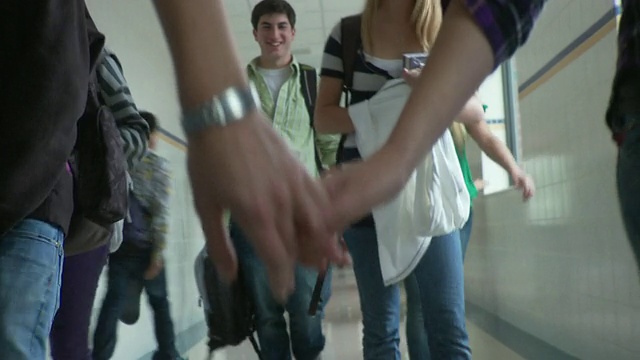 一对青少年情侣(16-17岁)手牵着手走在学校走廊上，美国纽约视频下载