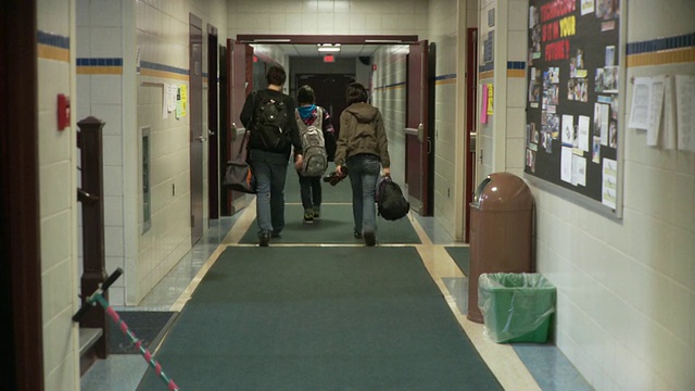 三个学生(15-16)走在学校走廊上，美国纽约Cazenovia视频素材