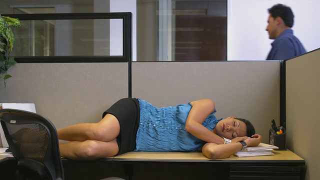 美国德克萨斯州奥斯丁市，一位在办公桌上睡觉的女士，一位路过的男士视频下载
