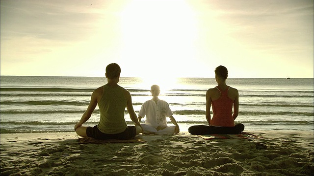 男子和女子在海滩上与冥想教练，华欣，普拉楚布基里汗，泰国视频下载