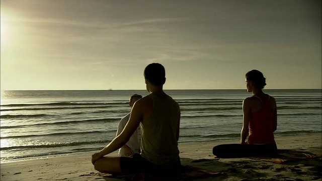 男子和女子在海滩上与冥想教练，华欣，普拉楚布基里汗，泰国视频下载