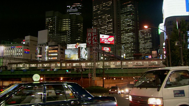 低角度中景拍摄新宿火车轨道下的交通和建筑背景/日本东京视频下载