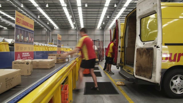 T/L WS快递公司将包裹从货车装载到新西兰奥克兰的摄食输送机上视频下载