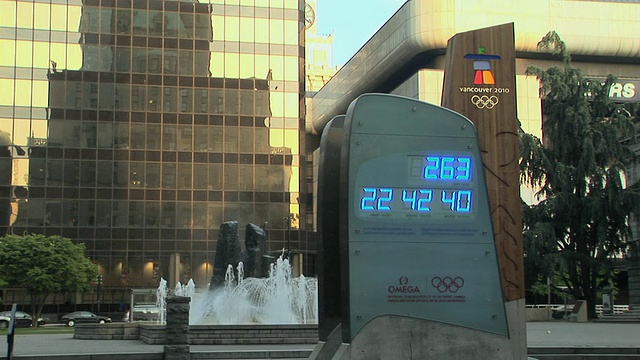 加拿大不列颠哥伦比亚省温哥华市的MS奥运倒计时钟，玻璃建筑背景中的费尔蒙特温哥华酒店视频素材