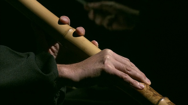 澳大利亚墨尔本，维多利亚，CU男子的手在演奏尺八长笛，背景中可以看到指挥家的手视频素材