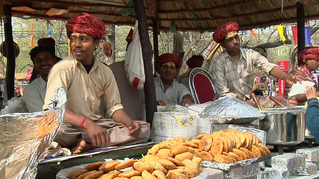 印度哈里亚纳邦法里达巴德的苏拉吉昆德集市上，男人们正在准备烤肉视频下载
