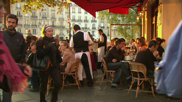 法国巴黎，顾客们坐在人行道上一家繁忙的咖啡馆里视频下载