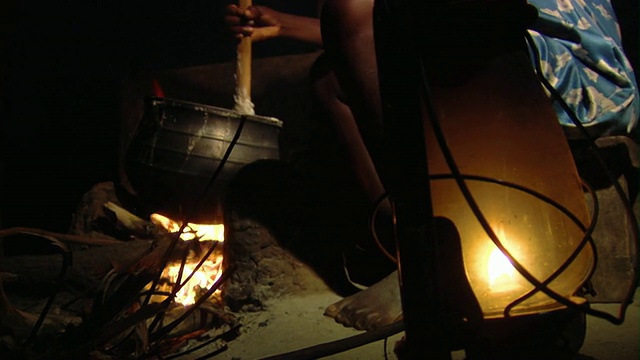 加纳，Tamale，晚上在明火上搅拌食物的人视频下载