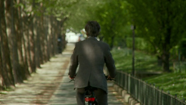 在法国巴黎的布尔吉巴滨海大道上，商人骑车远离镜头视频素材