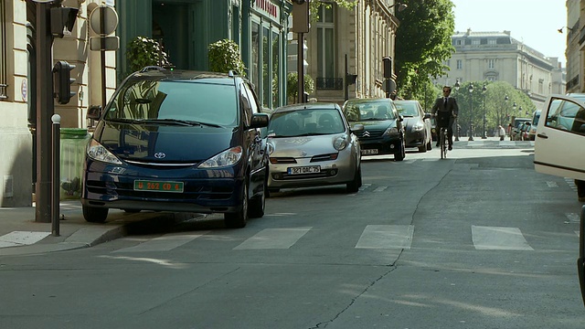 商人沿着街道骑车，下了自行车，走着，巴黎大学街，法国视频素材