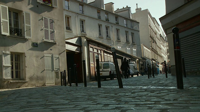 在法国巴黎修道院广场狭窄的街道上骑车的商人视频素材