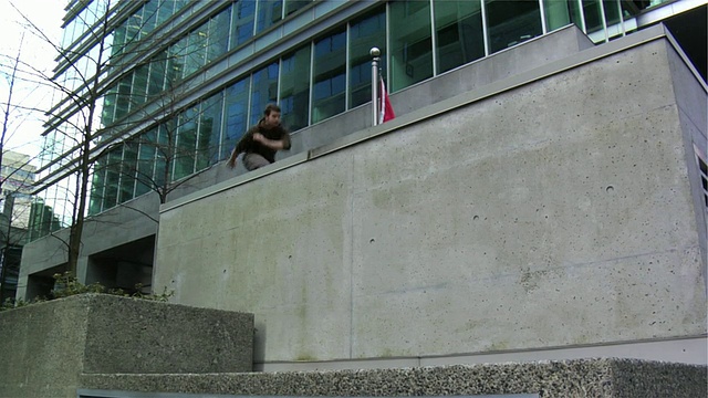 加拿大不列颠哥伦比亚省温哥华，两名男子跳墙跑上街头，表演跑酷视频下载