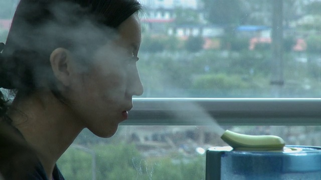 中国北京，一名女性办公室职员盯着电脑屏幕，加湿器向空气中喷射蒸汽视频下载