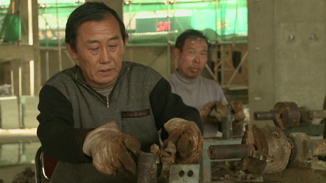中国云南昆明，两名工人在建筑工地加工金属零件视频素材