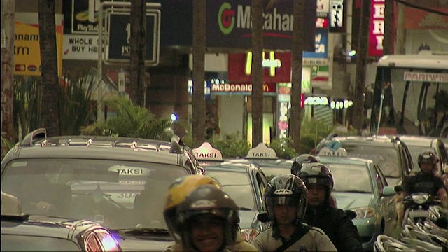 印度尼西亚巴厘岛，摩托车和汽车穿过城市街道视频下载