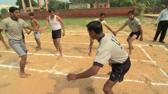 WS中学男孩穿着运动服在操场上玩摔跤游戏，德里区，印度视频下载
