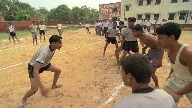 MS中学男孩穿着运动服在操场上玩摔跤游戏，德里区，印度视频下载
