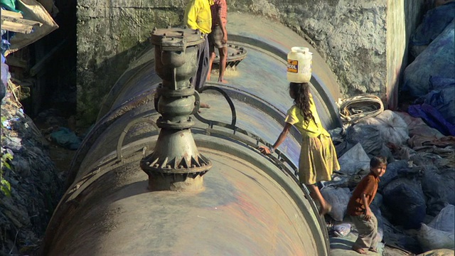 印度马哈拉施特拉邦孟买，女孩爬上水管，头上提着一桶水视频下载