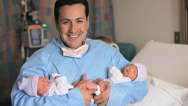 MS PORTRAIT父亲抱着刚出生的双胞胎，抬头微笑/美国弗吉尼亚州里士满视频素材