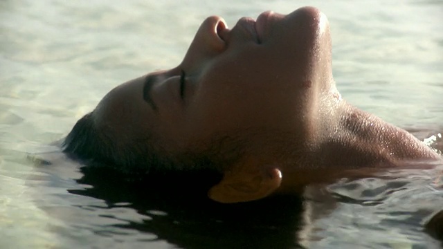特立尼达和多巴哥的斯卡伯勒海滩上，一名年轻女子漂浮在水中视频下载