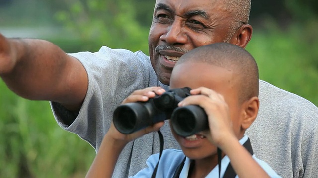 祖父和孙子(8-9岁)在户外使用双筒望远镜/里士满，弗吉尼亚州，美国视频素材